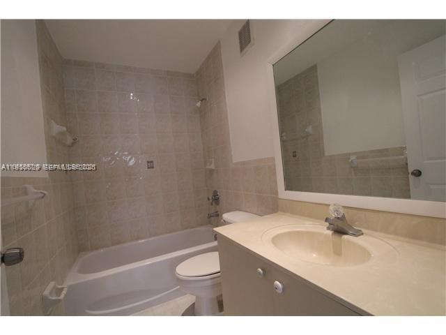 6761 Northwest 182nd Street, Unit 104 Hialeah, FL 33015 - Photo 9 of 12 a bathroom with a sink a toilet and shower
