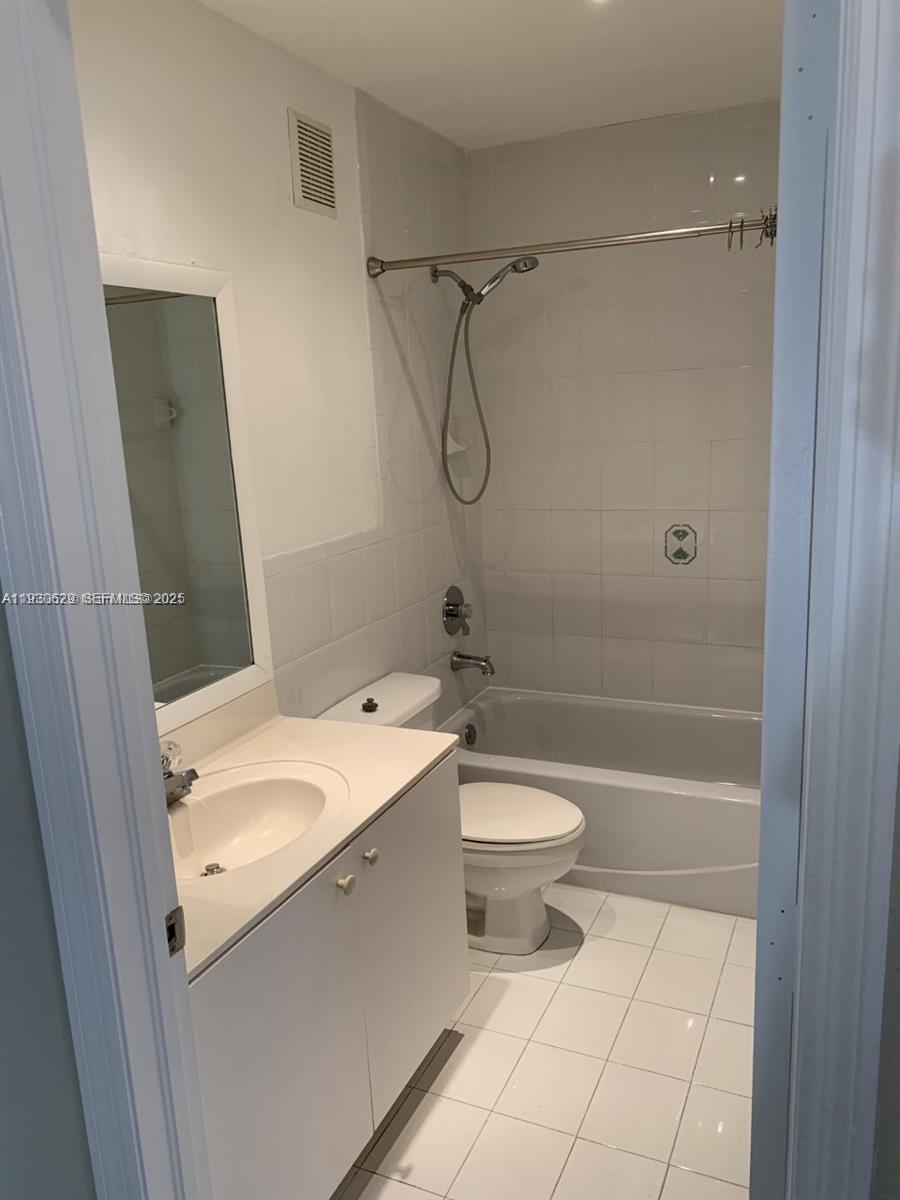 6761 Northwest 182nd Street, Unit 104 Hialeah, FL 33015 - Photo 10 of 12 a bathroom with a granite countertop sink toilet and shower
