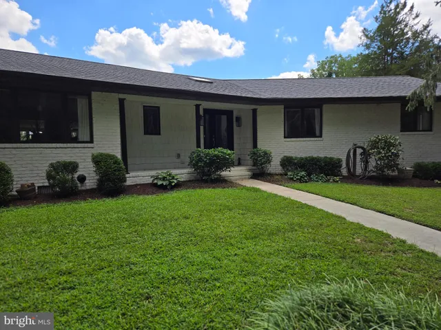a front view of a house with a garden and yard