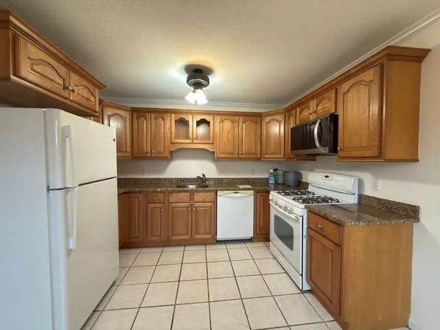 a kitchen with stainless steel appliances granite countertop a refrigerator and a sink
