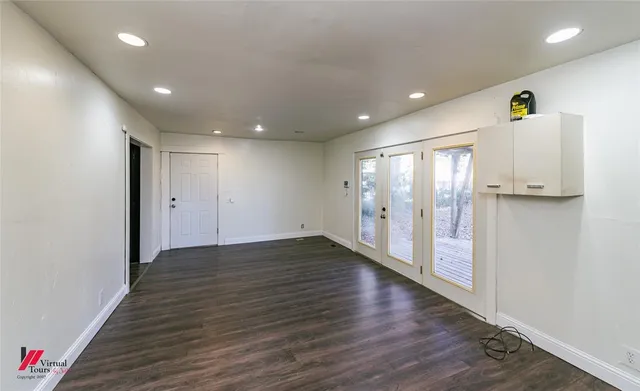 a view of an empty room with wooden floor