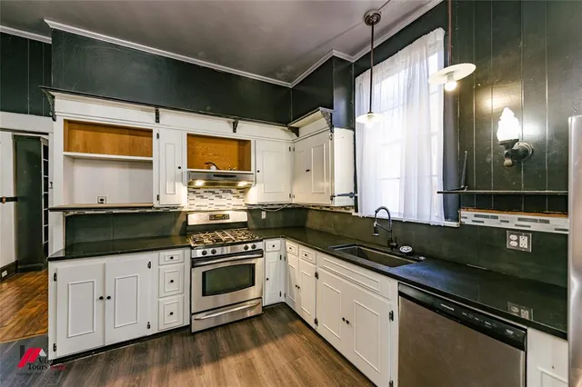 a kitchen with stainless steel appliances white cabinets and a stove