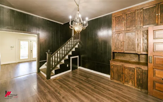 a view of a hallway with wooden floor and staircase