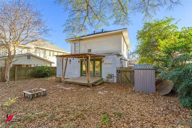 a view of a house with a yard and a wooden fence