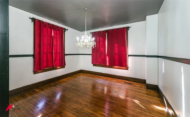 a view of a room with window wooden floor and front door