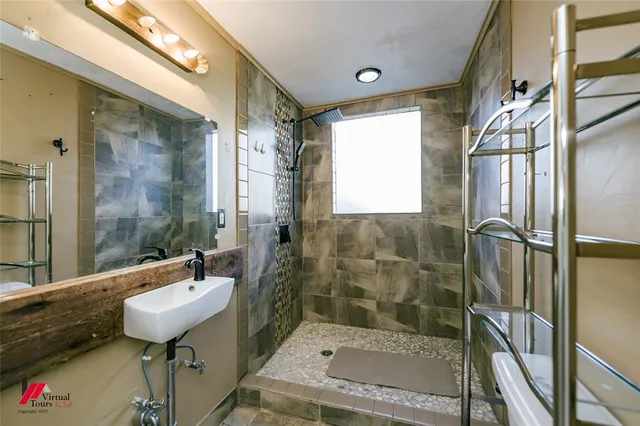a bathroom with a sink a toilet and shower