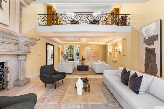 a dining room with furniture a chandelier a large window and potted plants