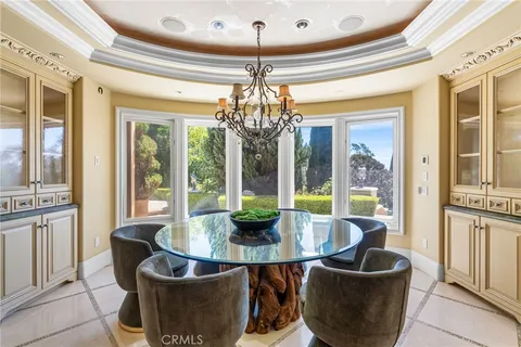 a dining room with furniture a chandelier and window