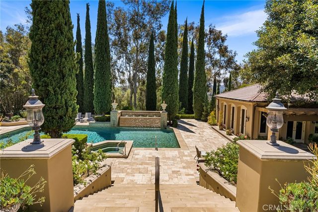 a view of swimming pool with lawn chairs and plants