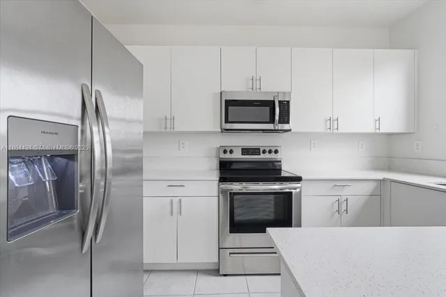 a kitchen with stainless steel appliances a refrigerator sink and microwave