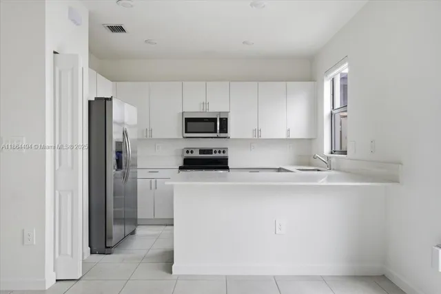 a kitchen with stainless steel appliances granite countertop a stove microwave and refrigerator