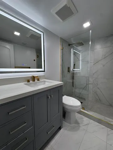 a bathroom with a sink a toilet and shower