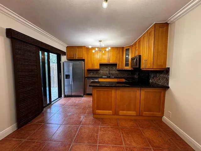 a kitchen with stainless steel appliances granite countertop a refrigerator and a stove top oven