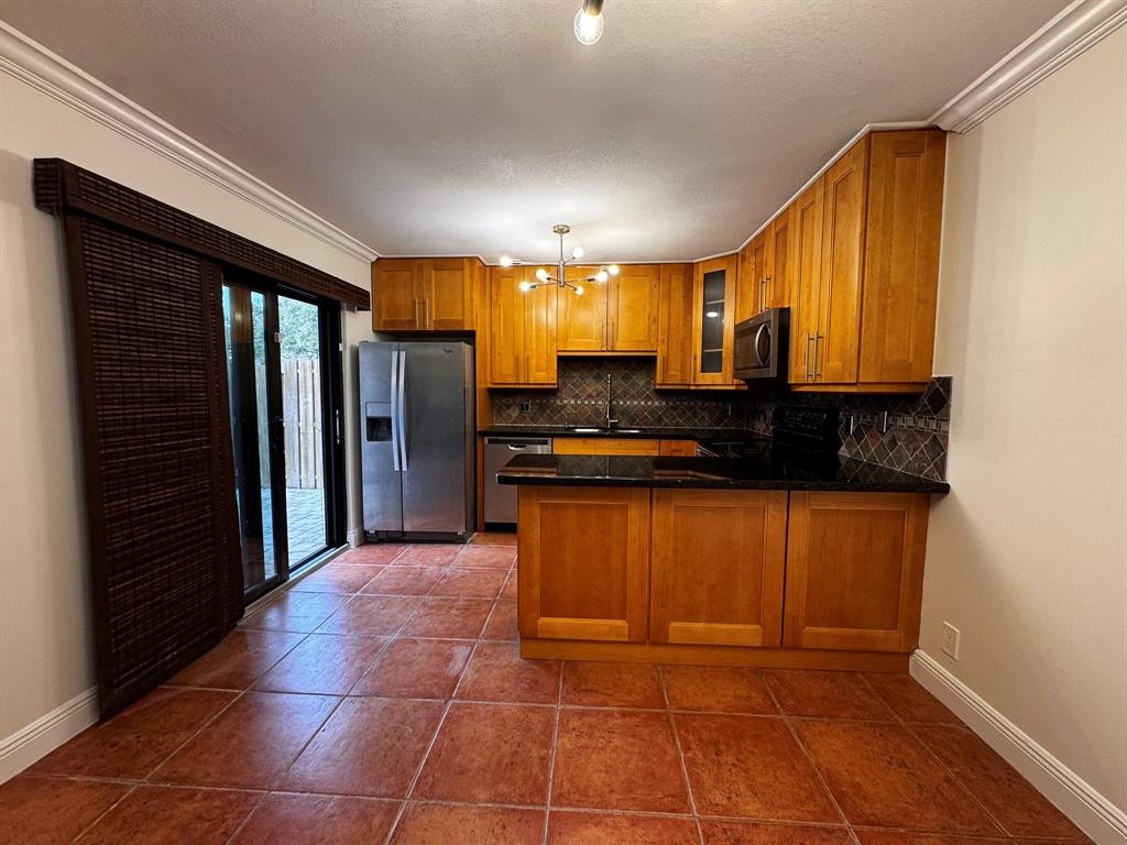 3205 Spanish Wells Drive, Unit C Delray Beach, FL 33445 - Photo 4 of 20 a kitchen with stainless steel appliances granite countertop a refrigerator and a stove top oven