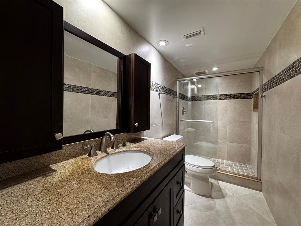 3205 Spanish Wells Drive, Unit C Delray Beach, FL 33445 - Photo 10 of 20 a bathroom with a granite countertop sink toilet and shower