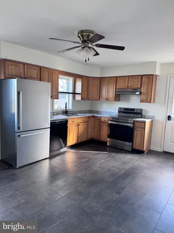 a kitchen with stainless steel appliances granite countertop a refrigerator sink and stove