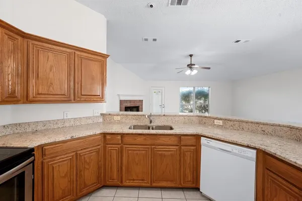 a kitchen with granite countertop cabinets sink and white appliances