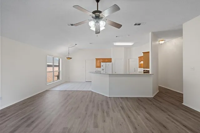 a view of a room with window ceiling fan and wooden floor
