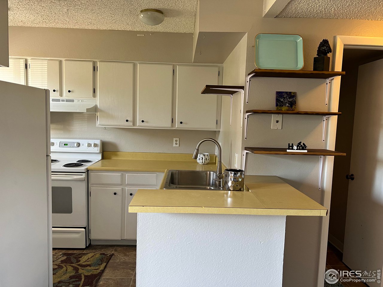 1705 Heatheridge Road, Unit 104 Fort Collins, CO 80526 - Photo 6 of 14 a kitchen with a sink a stove and cabinets