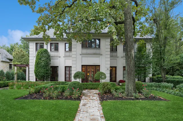 a front view of a house with a garden and plants