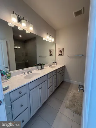 a bathroom with a double vanity sink and a mirror