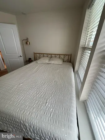 a bedroom with a bed and hardwood floor