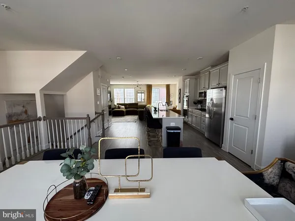 a living room with furniture and a refrigerator