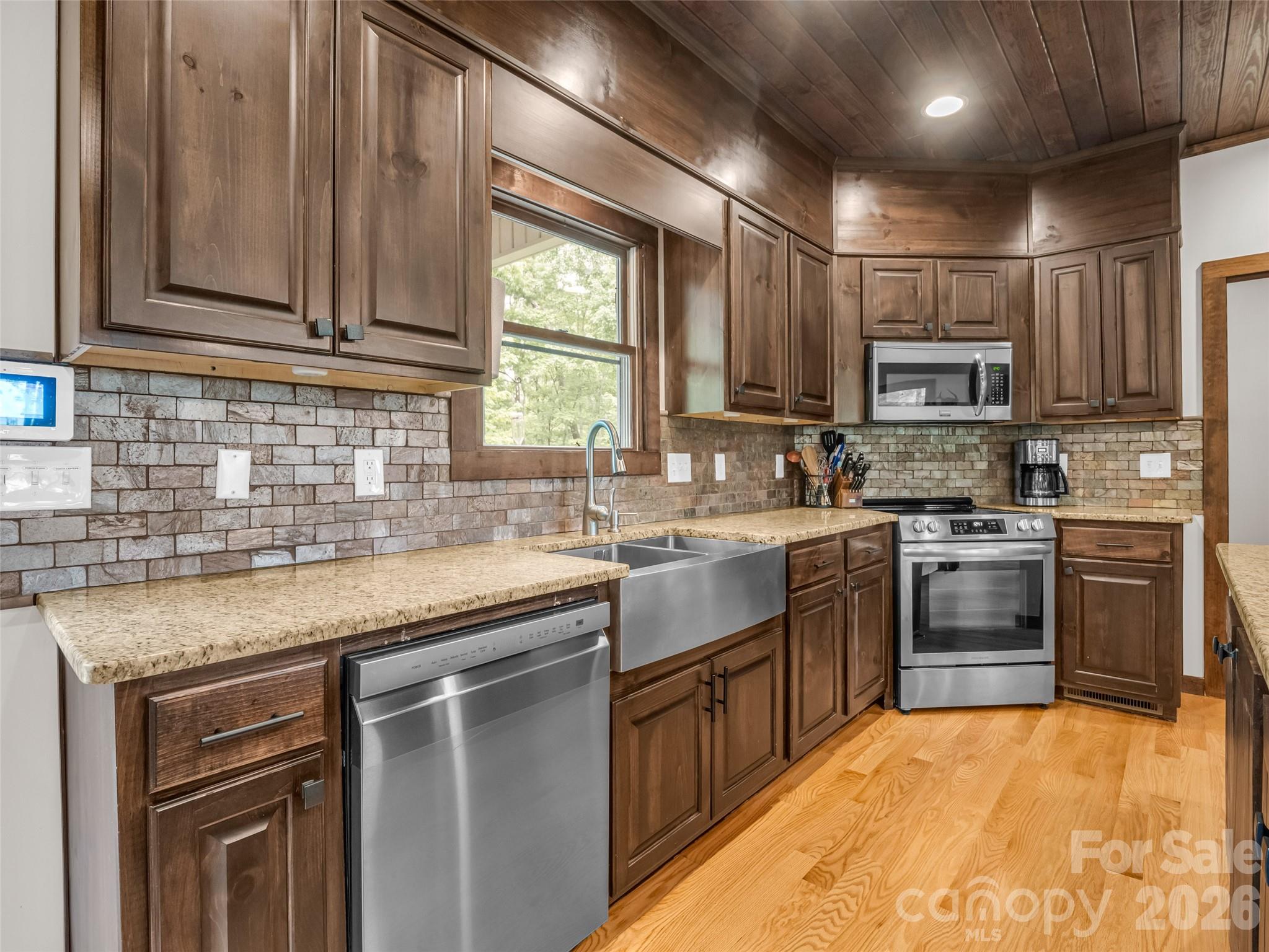139 Picnic Point Road Lake Lure, NC 28746 - Photo 13 of 41 a kitchen with stainless steel appliances granite countertop a sink stove cabinets and refrigerator