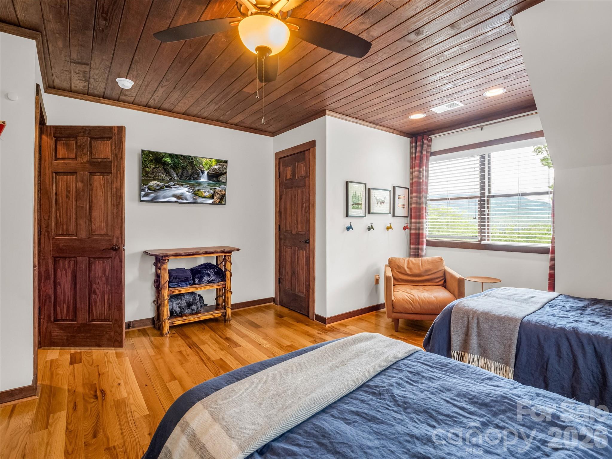 139 Picnic Point Road Lake Lure, NC 28746 - Photo 24 of 41 a bedroom with two beds and a chandelier