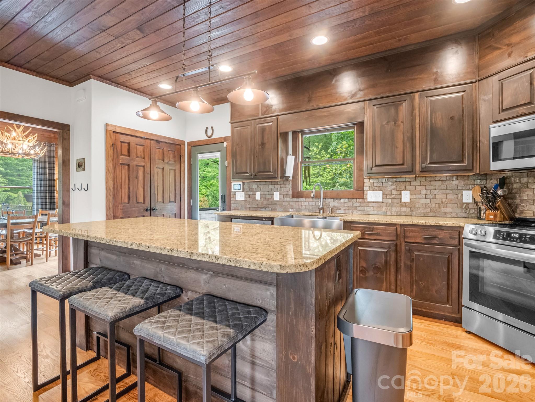 139 Picnic Point Road Lake Lure, NC 28746 - Photo 8 of 41 a kitchen with kitchen island granite countertop a sink window and cabinets