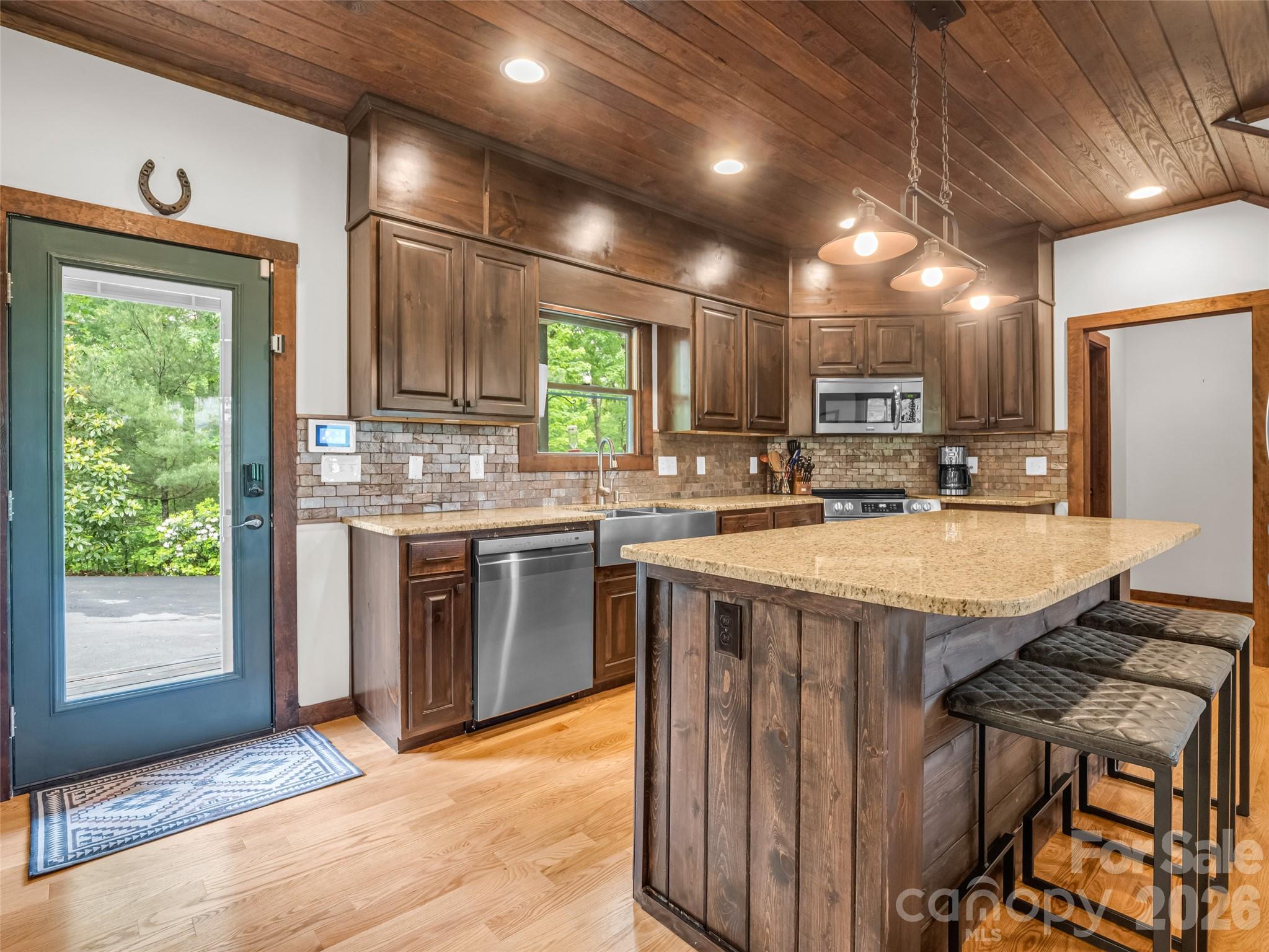 139 Picnic Point Road Lake Lure, NC 28746 - Photo 9 of 41 a kitchen with kitchen island granite countertop a stove and a sink