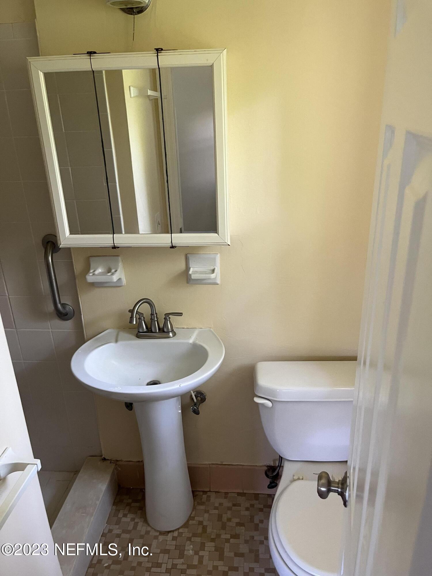 5418 Juno Drive Jacksonville, FL 32207 - Photo 14 of 19 a bathroom with a sink a toilet and mirror