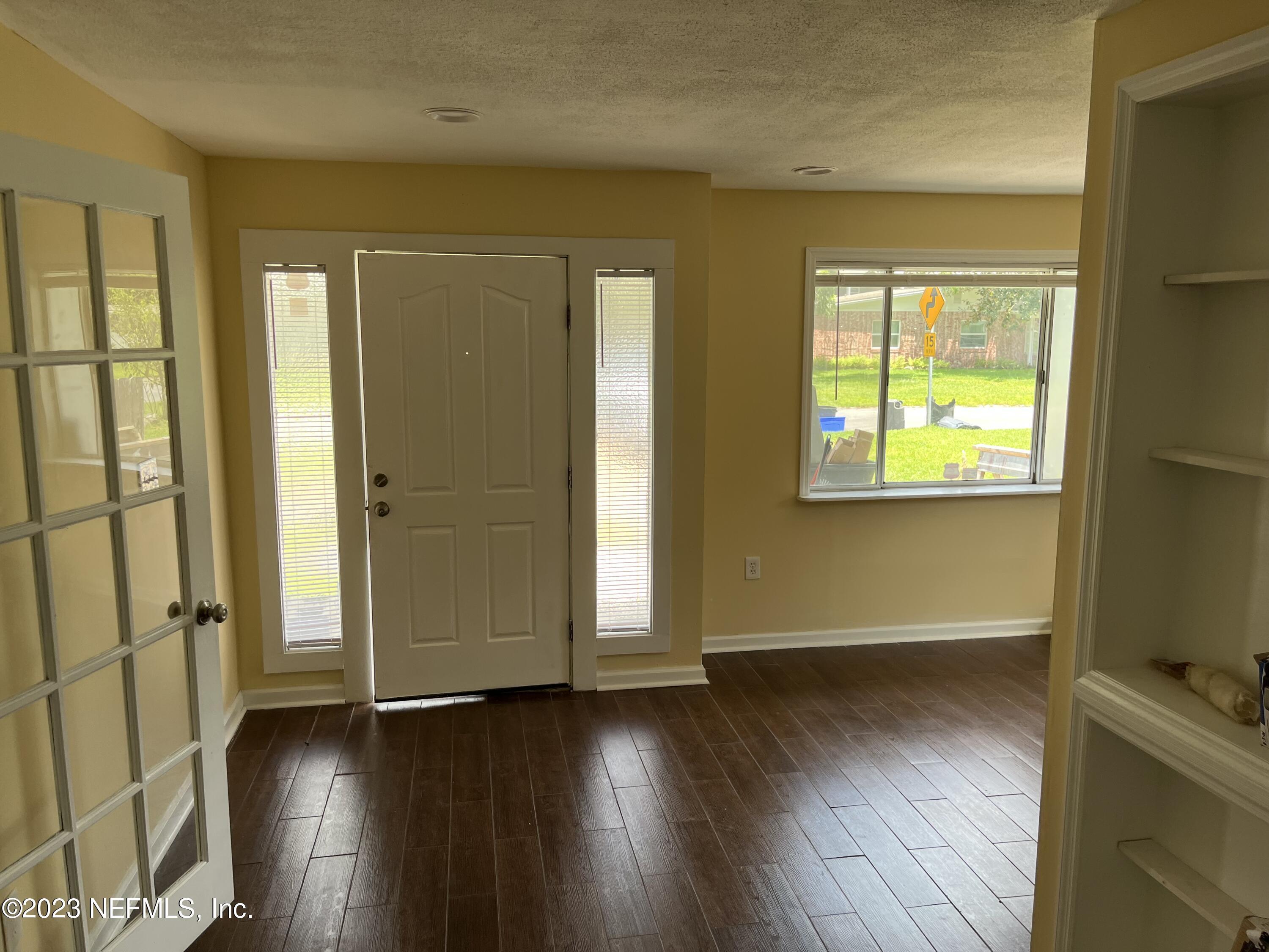 5418 Juno Drive Jacksonville, FL 32207 - Photo 7 of 19 an empty room with wooden floor and windows