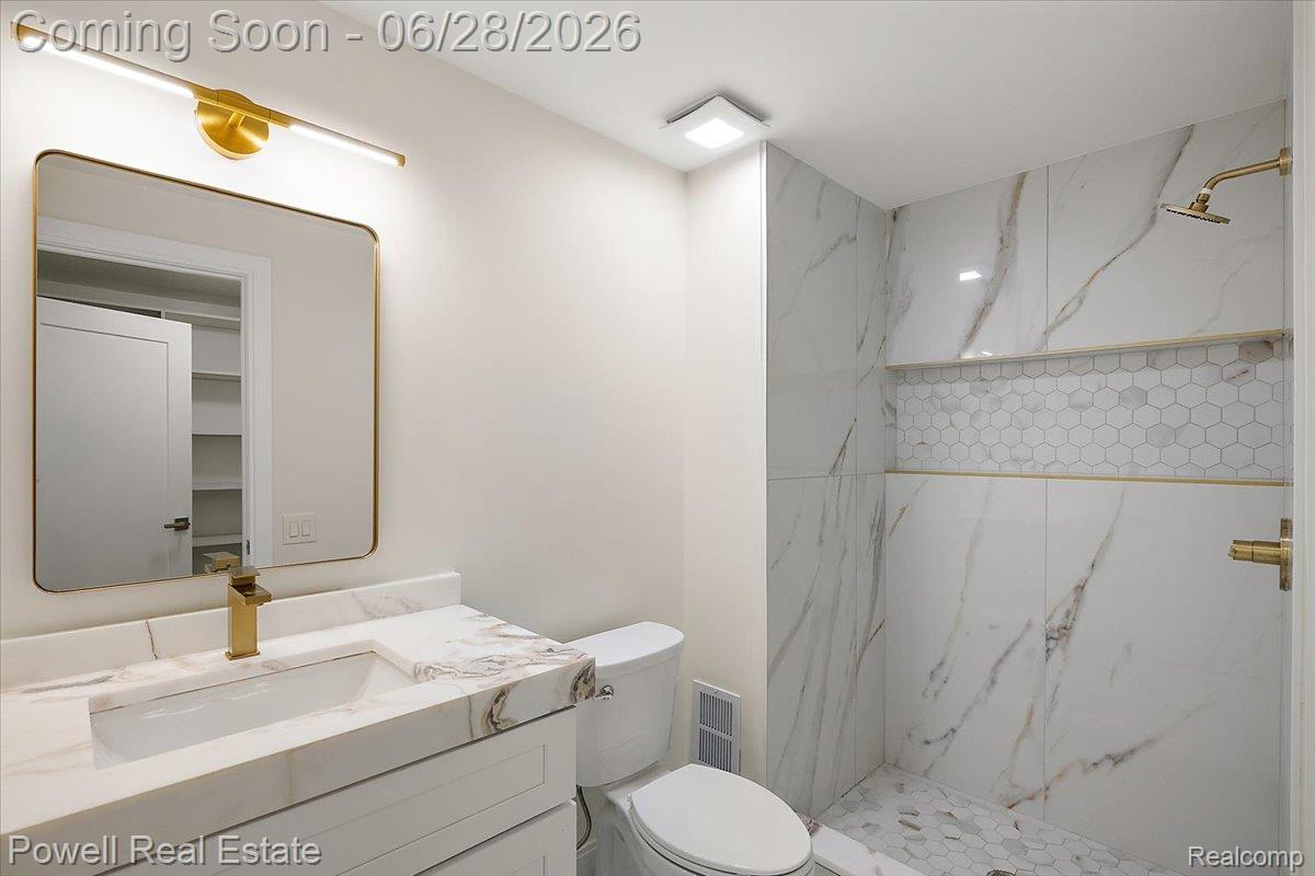 1447 Ravineview Court, Unit C12 Bloomfield Hills, MI 48304 - Photo 34 of 49 Well-appointed bathroom featuring a gold-framed mirror, contemporary gold-tone vanity faucet, and a coordinated gold-tone shower fixture