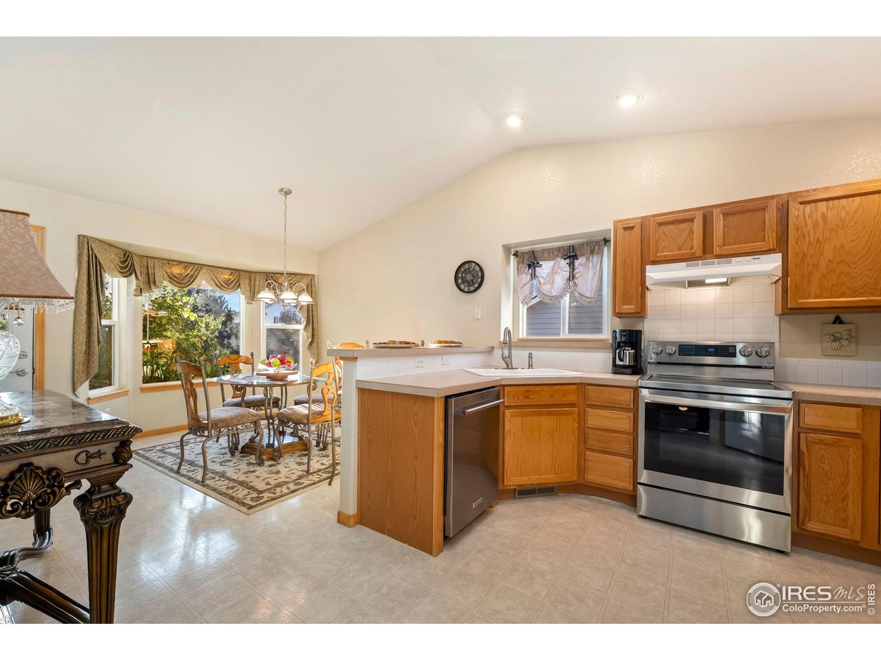 623 Foxtail Way Severance, CO 80550 - Photo 11 of 27 a kitchen with stainless steel appliances granite countertop a stove and white cabinets