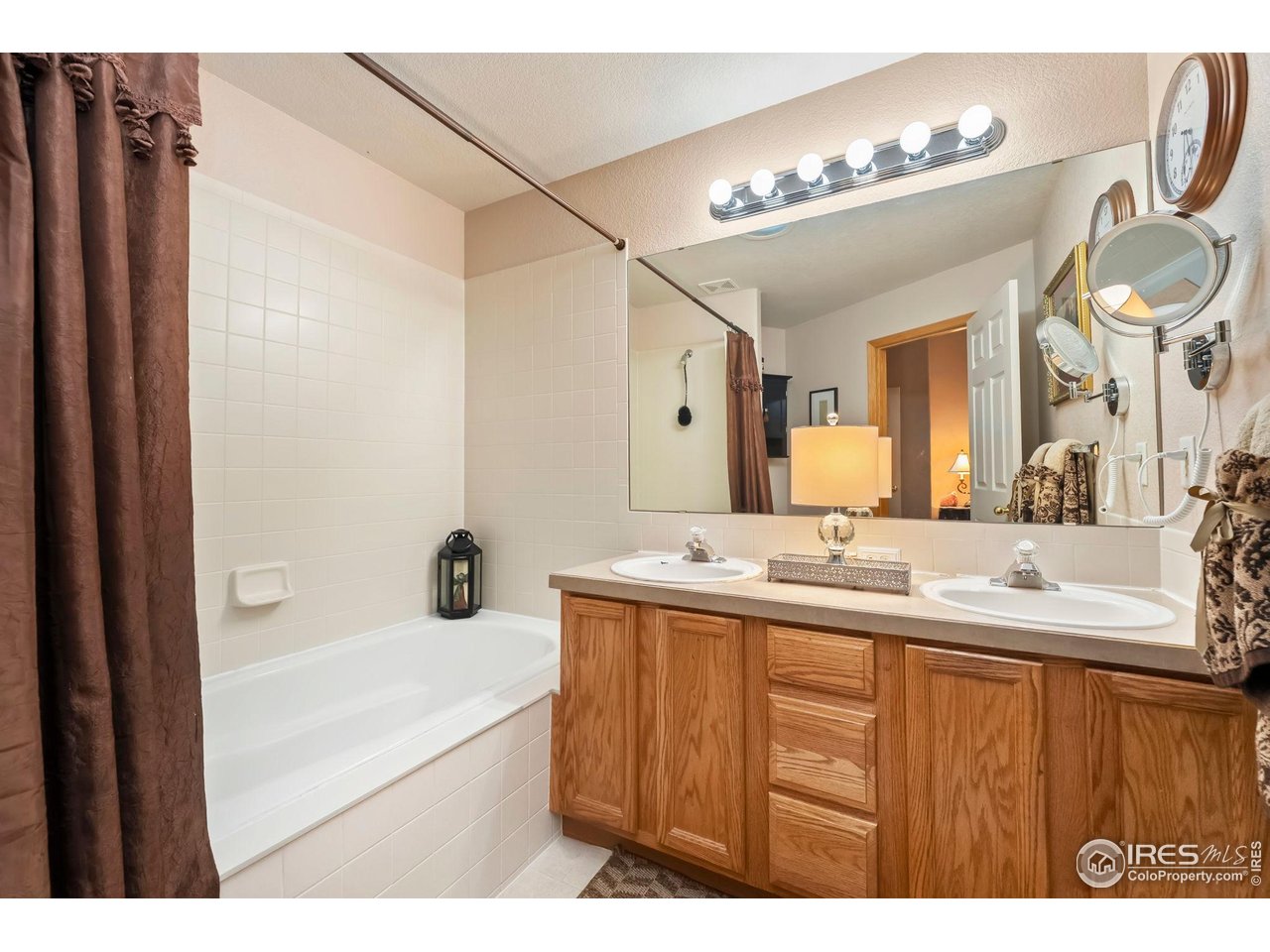 623 Foxtail Way Severance, CO 80550 - Photo 18 of 27 a bathroom with a tub a sink and mirror