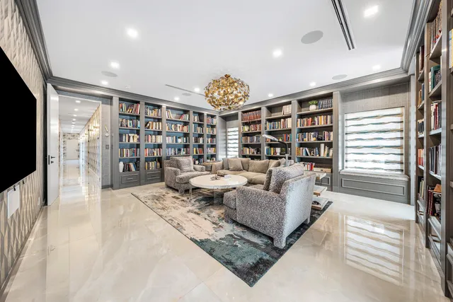 a living room with couches a flat screen tv and a fireplace