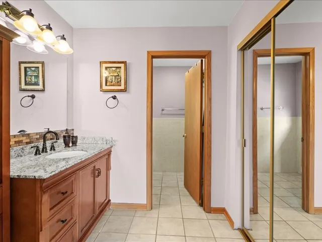 a spacious bathroom with a granite countertop sink and a mirror