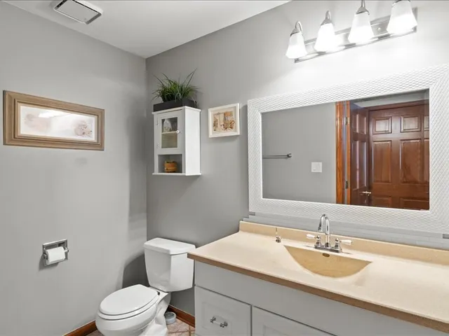 a bathroom with a sink a toilet and a mirror