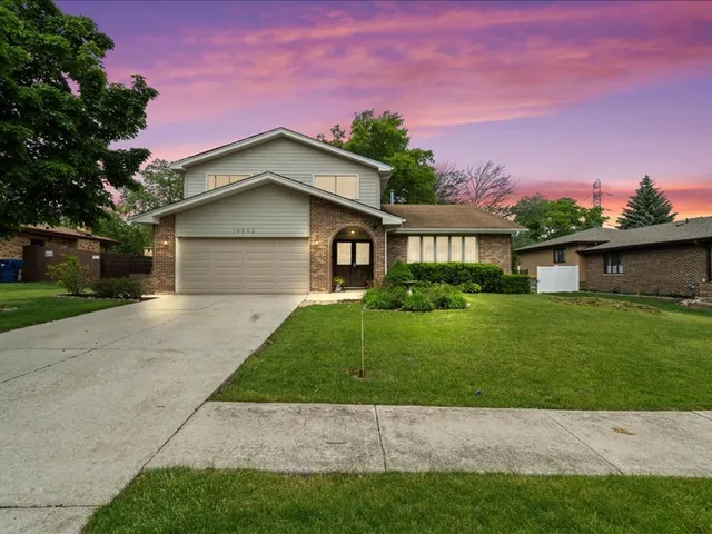 a front view of a house with a garden and yard