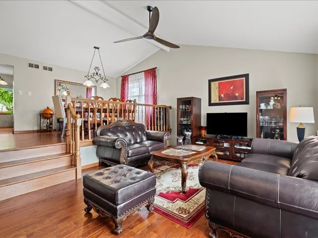 a living room with furniture a flat screen tv and a chandelier