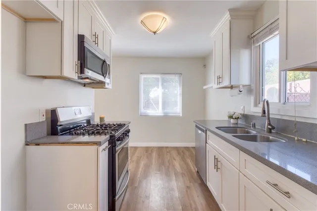 a kitchen with stainless steel appliances granite countertop a sink stove and cabinets