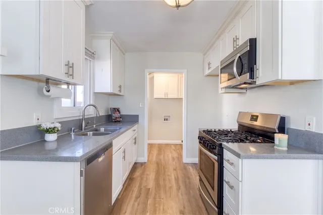 a kitchen with stainless steel appliances granite countertop a sink stove and cabinets