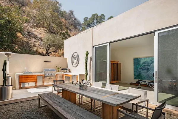 a view of a dinning table and chairs in patio of the house