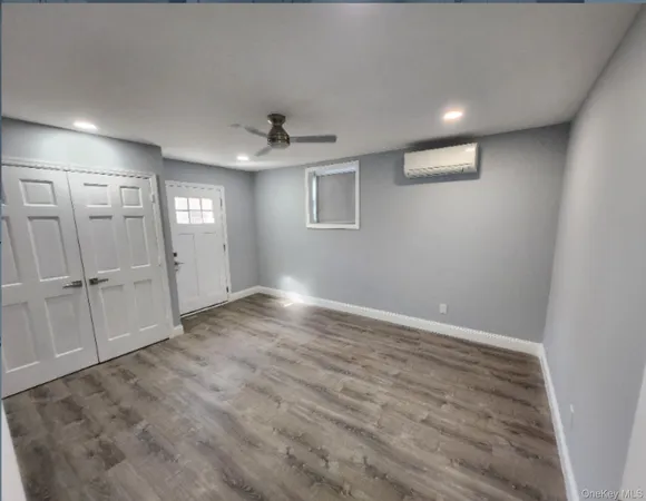 an empty room with windows and cabinet