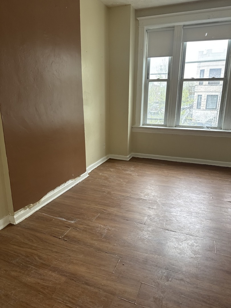 1655 South Ridgeway Avenue Chicago, IL 60623 - Photo 11 of 19 an empty room with wooden floor and windows
