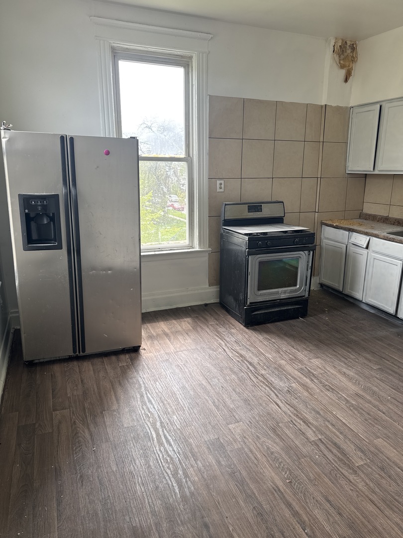 1655 South Ridgeway Avenue Chicago, IL 60623 - Photo 12 of 19 a kitchen with granite countertop a refrigerator and a stove top oven