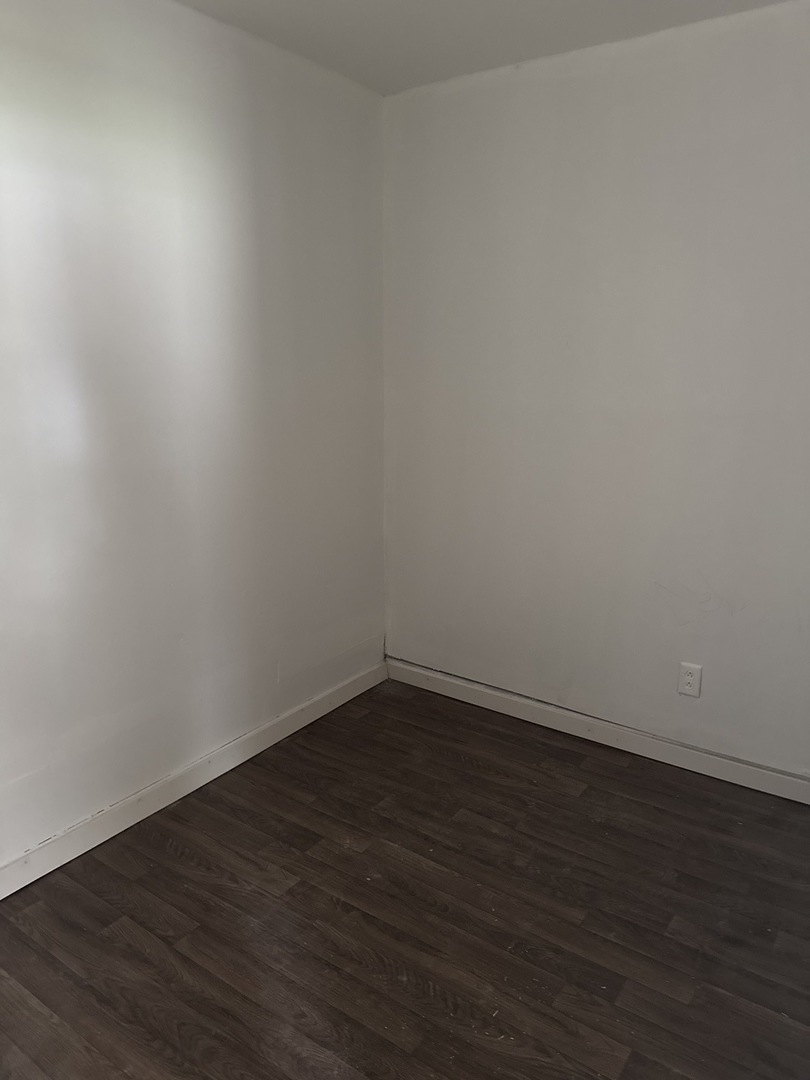 1655 South Ridgeway Avenue Chicago, IL 60623 - Photo 4 of 19 a view of an empty room with wooden floor and a window