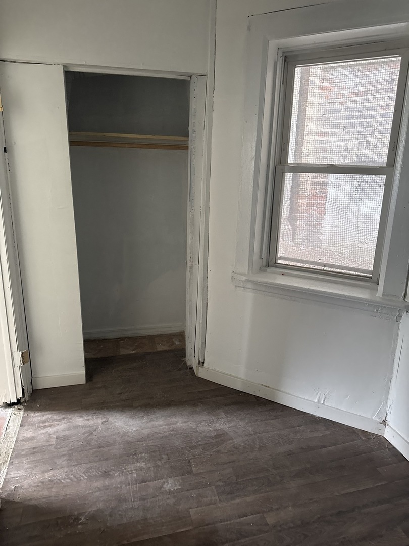 1655 South Ridgeway Avenue Chicago, IL 60623 - Photo 5 of 19 an empty room with wooden floor and windows