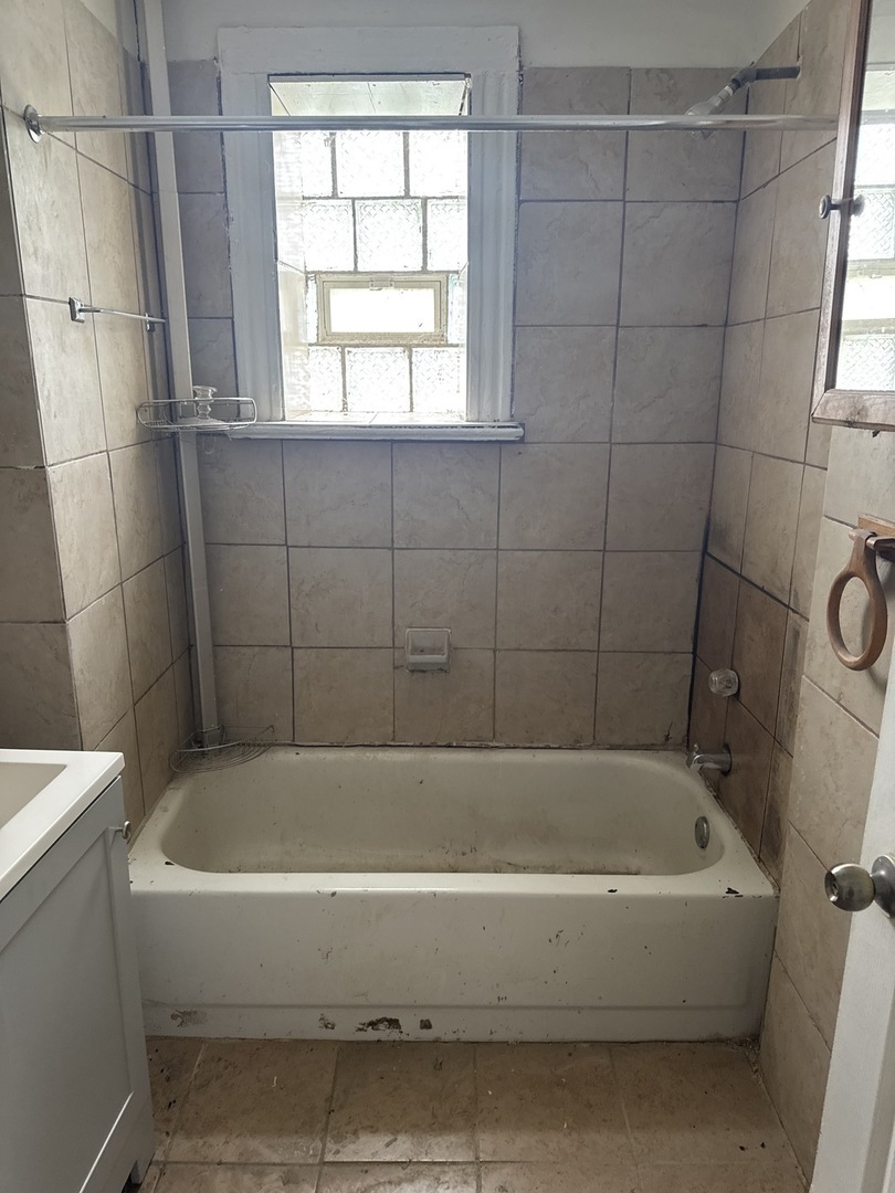 1655 South Ridgeway Avenue Chicago, IL 60623 - Photo 6 of 19 a white bath tub sitting next to a white sink and vanity